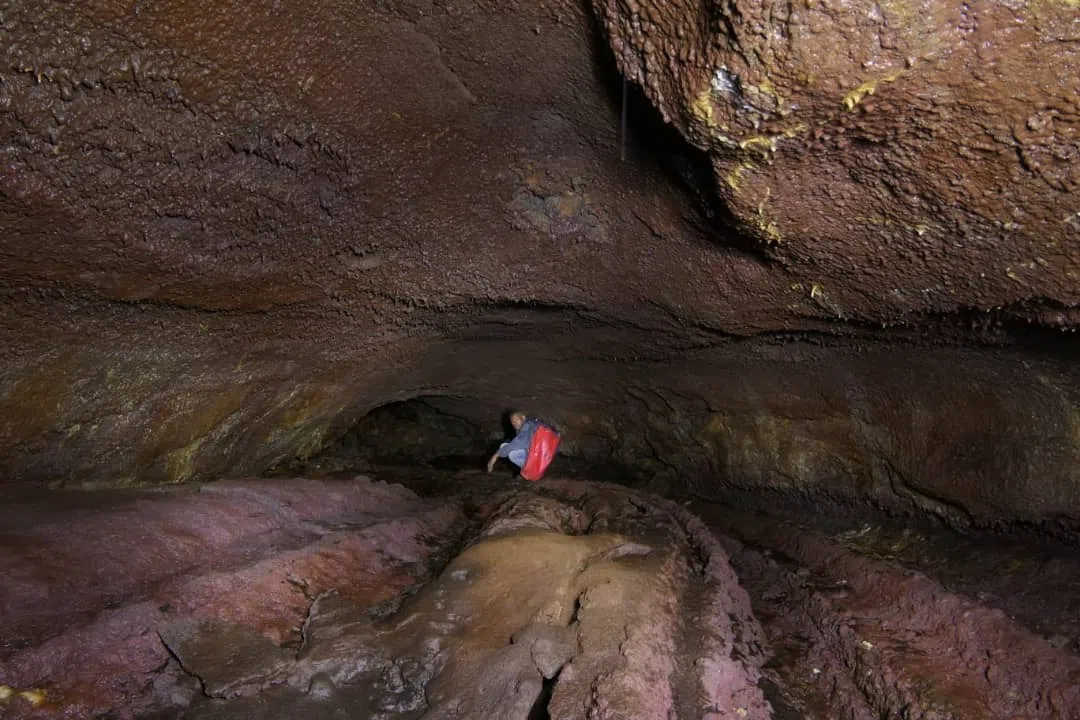 a deep cave with an individual going inside